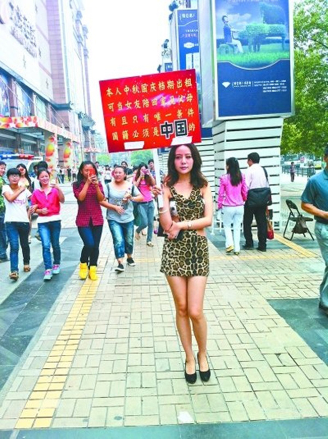 Một cô gái trẻ ăn mặc mát mẻ xuất hiện trên đường Giang Hán (Trung Quốc) tay giơ cao tấm biển tuyên bố cho thuê… thân.